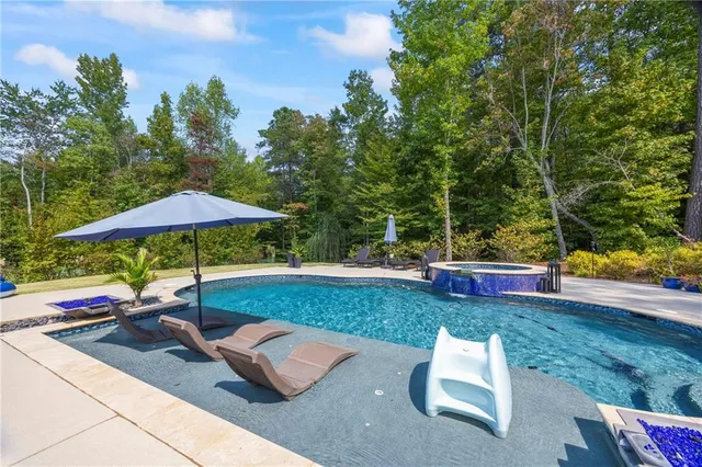 a swimming pool with outdoor seating and plants