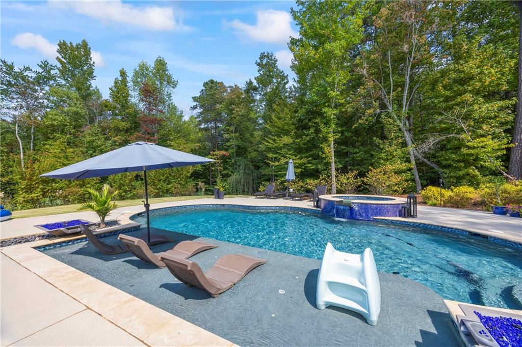 3111 Old Thompson Mill Road Buford, GA 30519 - Photo 46 of 52 an outdoor sitting area with furniture and umbrella