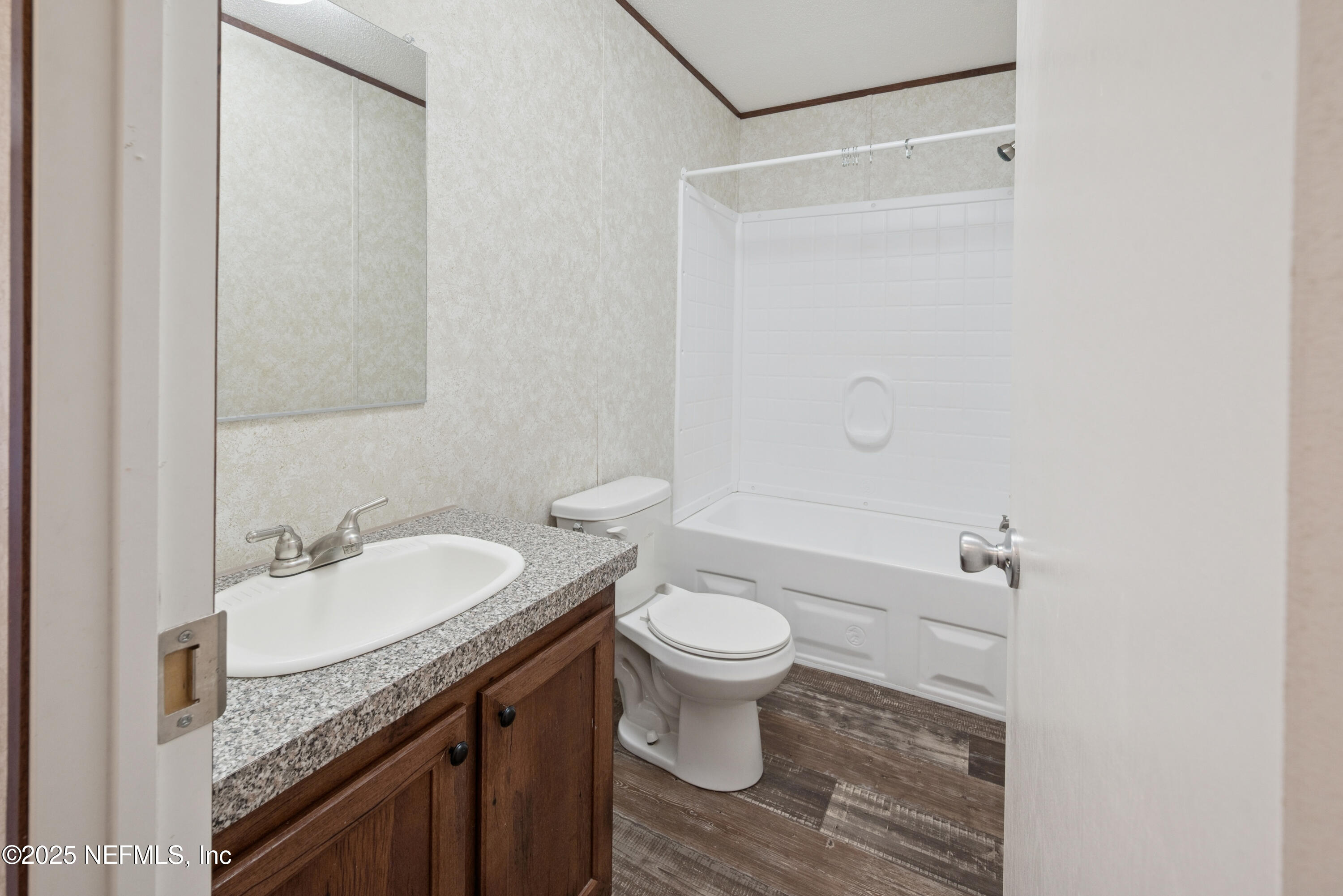10379 Southwest 45th Place Lake Butler, FL 32054 - Photo 16 of 24 a bathroom with a granite countertop sink a toilet and a mirror