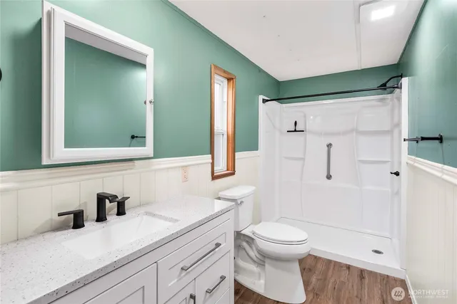 a bathroom with a sink a toilet and shower