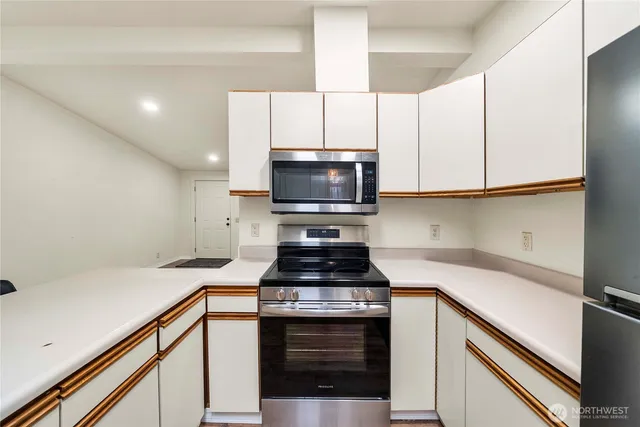 a kitchen with granite countertop a stove and a microwave