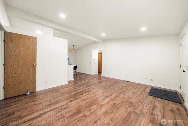 a view of empty room with wooden floor