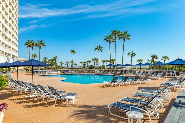 a view of a swimming pool with a table and chairs under an umbrella