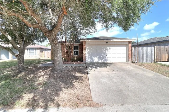 a view of a house with a yard and tree