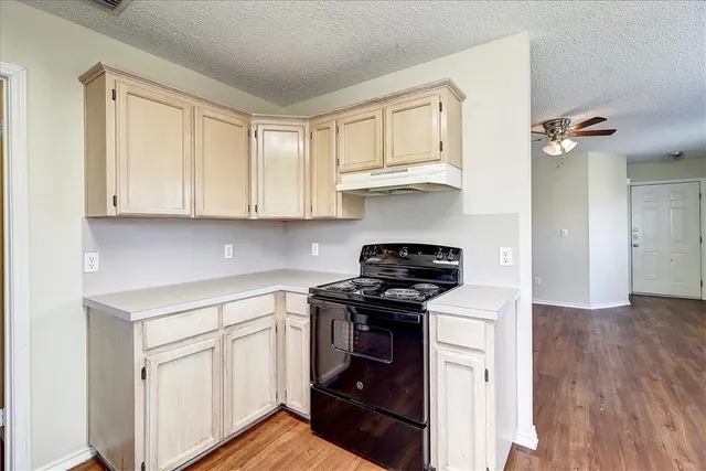 a kitchen with white cabinets and appliances