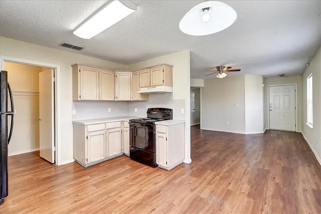 a kitchen with a refrigerator and a stove top oven