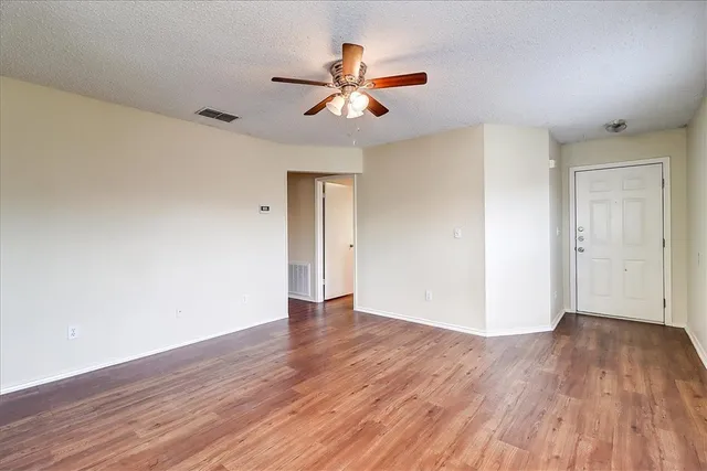 a view of an empty room with wooden floor