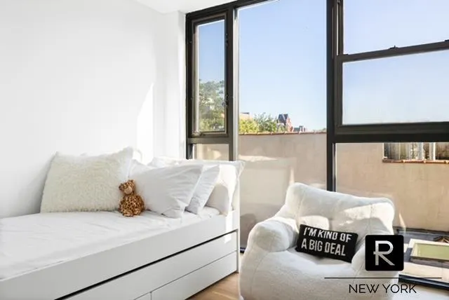 a bed sitting in a bedroom next to a window