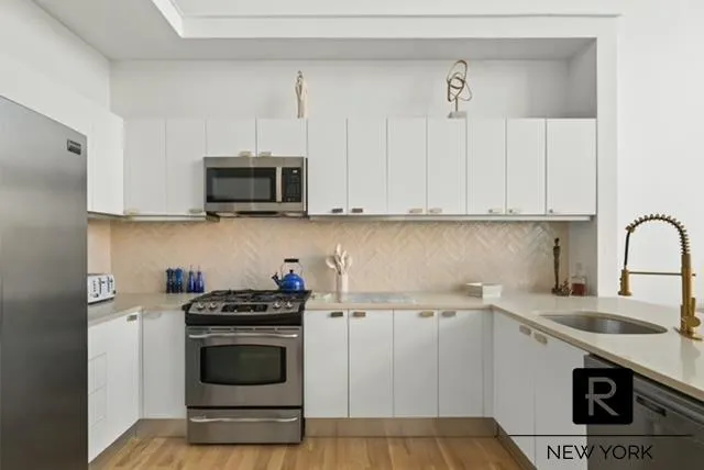 a kitchen with granite countertop a stove a sink and a microwave