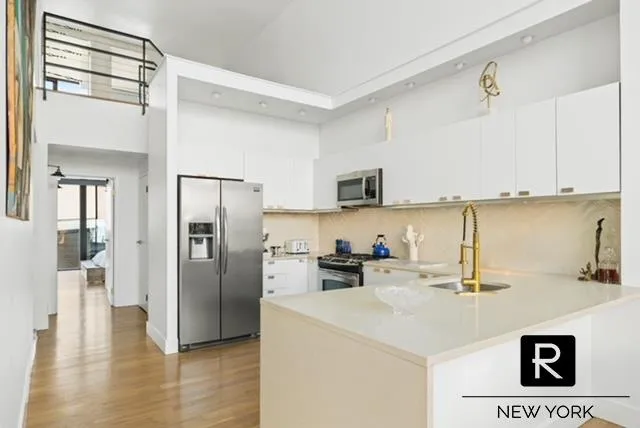 a kitchen with a sink a refrigerator and cabinets