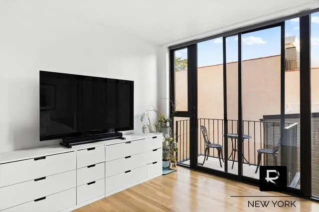 a living room with flat screen tv and floor to ceiling window