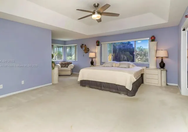 a bedroom with a large bed chandelier and a window