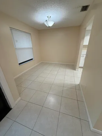 a view of kitchen and empty room with wooden floor