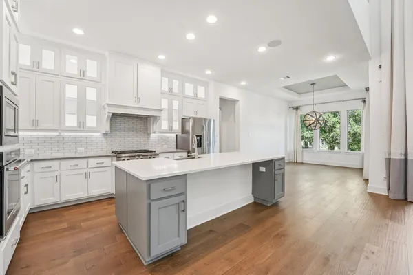 a kitchen with kitchen island a sink stainless steel appliances and cabinets