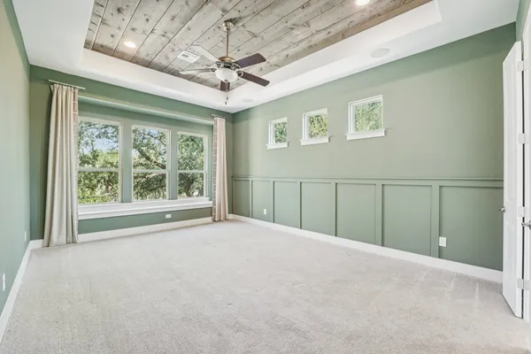 an empty room with windows and ceiling fan