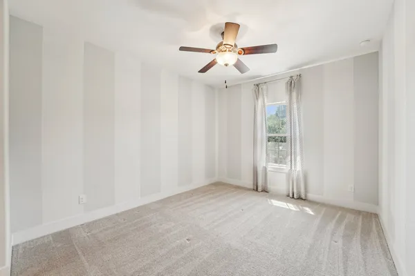 a view of a room with wooden floor and ceiling fan