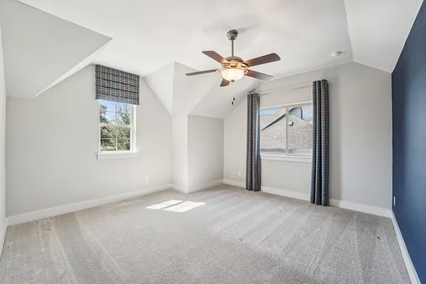an empty room with a ceiling fan and a window