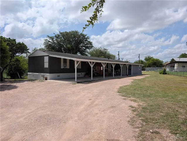 a view of a house with backyard and sitting area