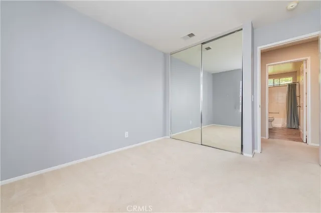 a bathroom with a granite countertop double vanity sink a mirror and a shower