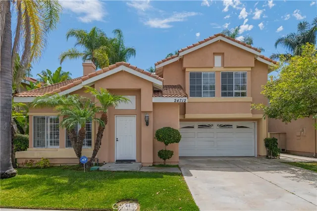 a front view of a house with a garden and plants