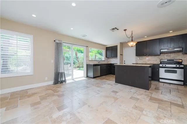 a large kitchen with stainless steel appliances granite countertop a stove and a sink