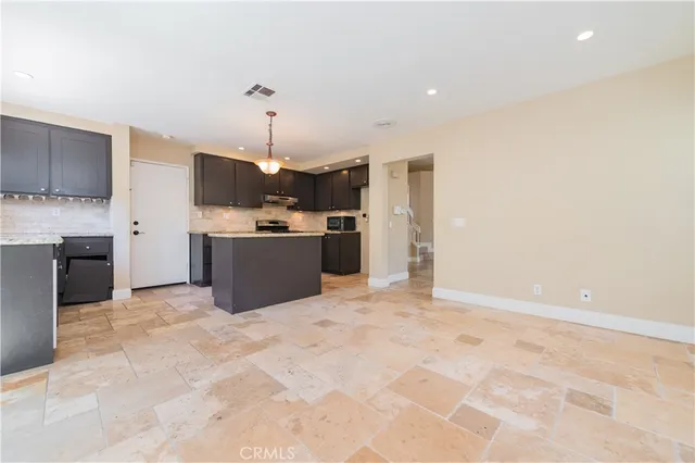 a kitchen with kitchen island a stove a refrigerator and a sink