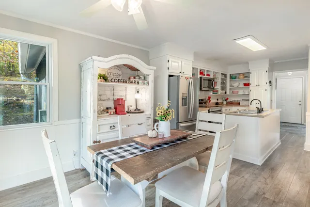 a view of a dining room with furniture a chandelier and wooden floor