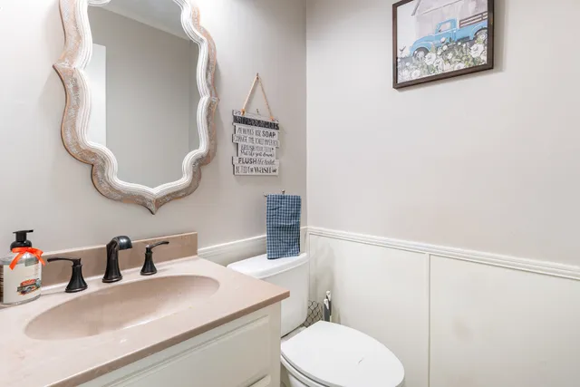a bathroom with a sink vanity mirror and toilet