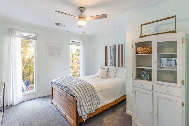 a bedroom with a large bed a chandelier and windows