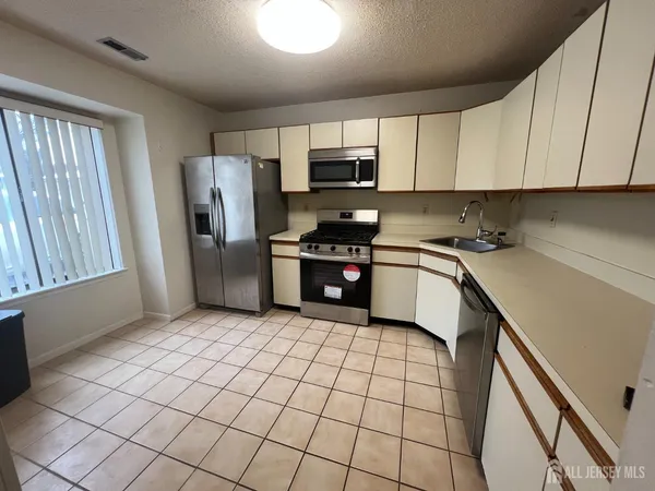 a kitchen with stainless steel appliances granite countertop a refrigerator sink and cabinets