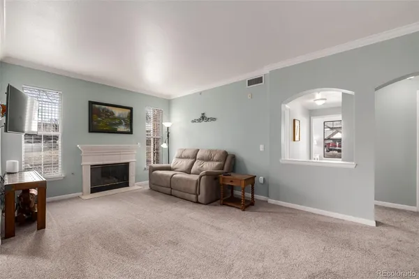 a living room with furniture and a dining table with kitchen view