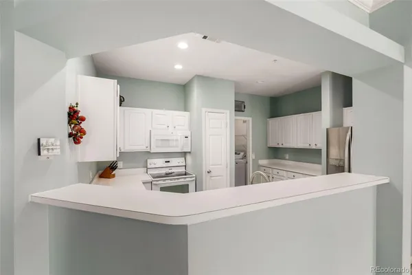 a kitchen with white cabinets and sink