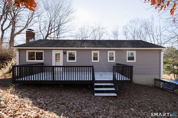 a view of a house with a yard and wooden fence