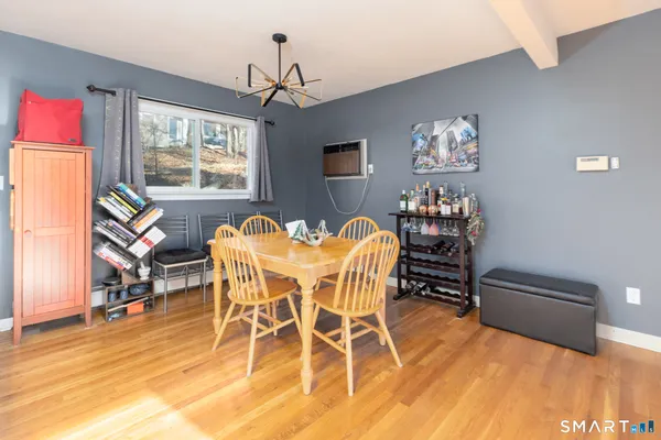 a dining room with furniture a chandelier and wooden floor