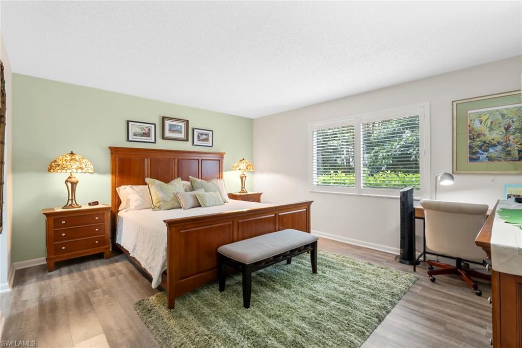 500 Teryl Road, Unit 1 Naples, FL 34112 - Photo 13 of 20 a bedroom with a bed and a lounge chair