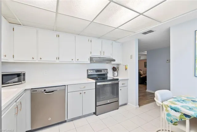 a kitchen with a stove sink and cabinets