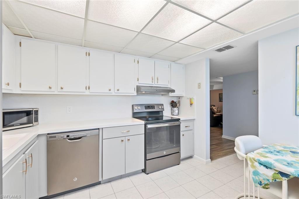 500 Teryl Road, Unit 1 Naples, FL 34112 - Photo 7 of 20 a kitchen with a stove sink and cabinets