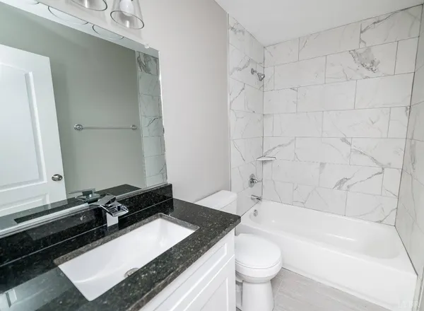 a bathroom with a granite countertop sink toilet and shower