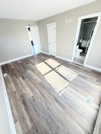 a view of a livingroom with wooden floor and furniture
