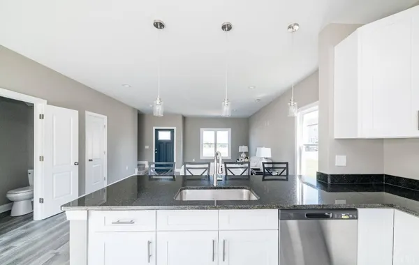 a large kitchen with granite countertop a large counter top stainless steel appliances and cabinets