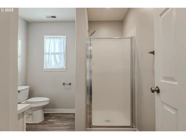 a bathroom with a toilet and a shower