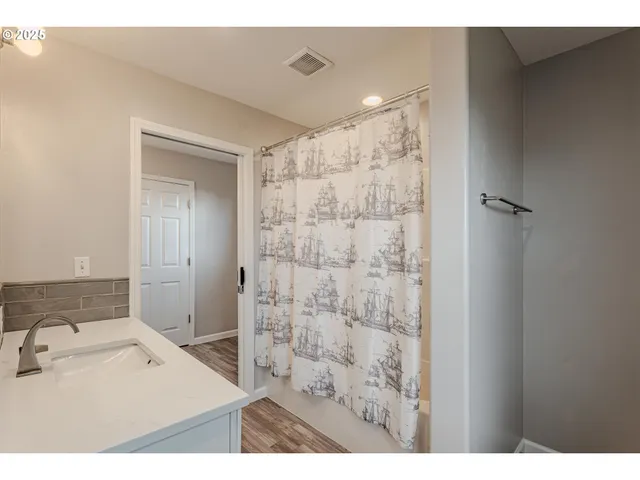 a bathroom with a sink mirror and shower