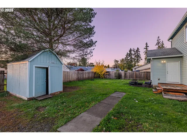 a backyard of a house with plants and wooden fence