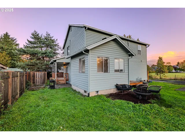 a backyard of a house with table and chairs