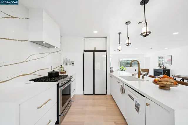 a kitchen with stainless steel appliances a sink stove and refrigerator