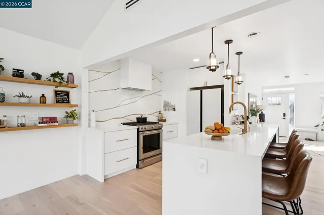 a kitchen that has a lot of cabinets a sink and appliances