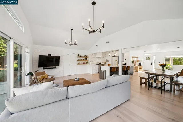 a living room with furniture kitchen view and a flat screen tv