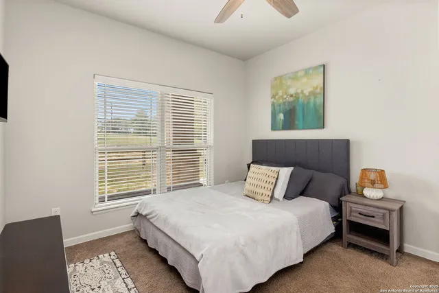 a bedroom with a bed and a large window