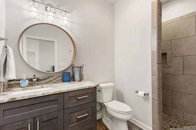a bathroom with a granite countertop sink and a mirror