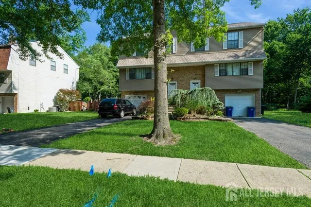 a front view of a house with a garden and yard